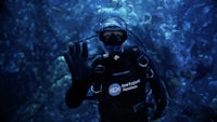 a scuba diver waving his hand in the water