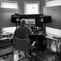 a man sitting at a desk in a recording studio